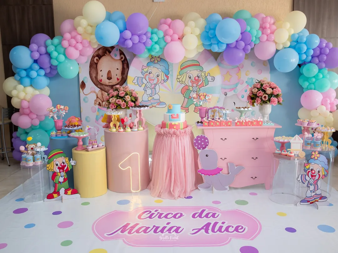 Decoração de circo em tons pastel com arco de balões coloridos, palhaços e animais